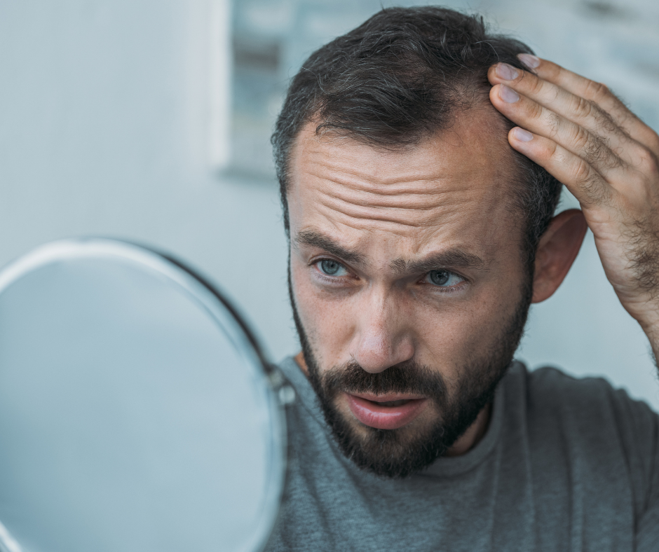 Photo d'un homme qui regarde ses cheveux dans le miroir